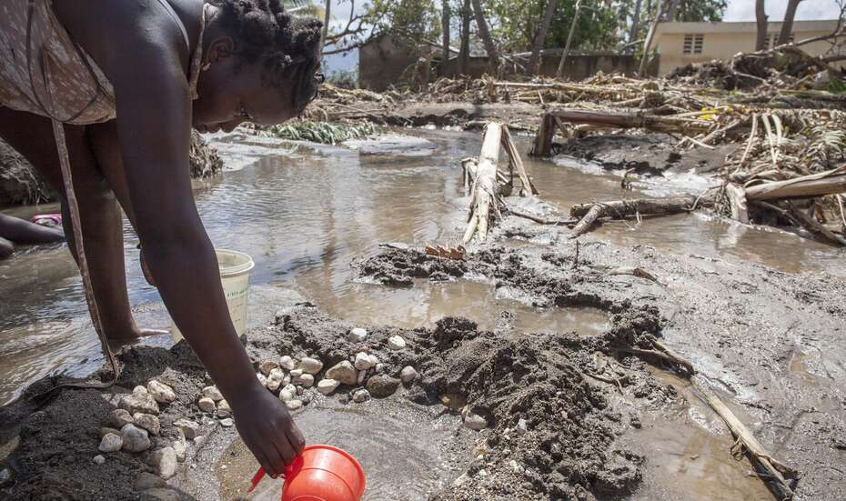 Eine Frau in Haiti schöpft nach Hurrikan Matthew verschmutztes Wasser