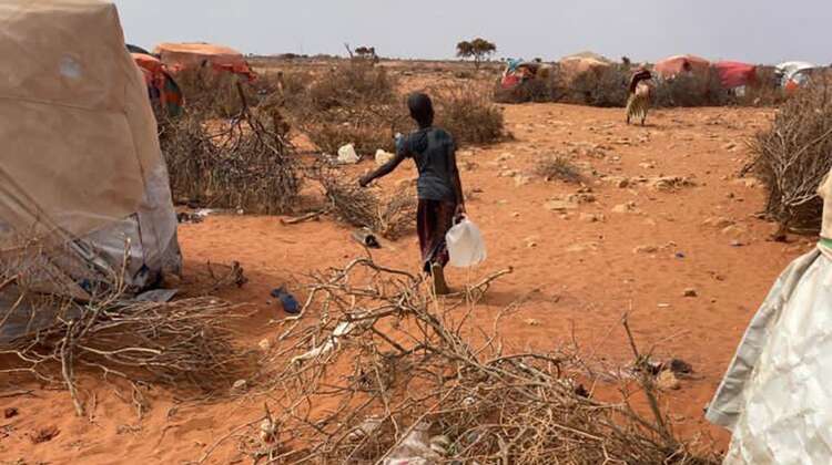 Ein Junge von hinten mit einem Wasserkanister in der Hand.