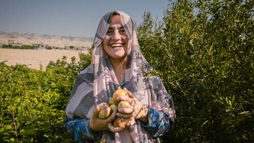 Eine Frau präsentiert ihre Ernte auf einer Plantage im Irak.