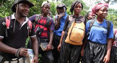 Fünf Menschen stehen im Wald.
