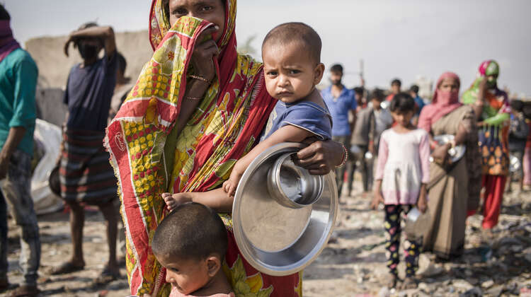 Eine Frau wartet in Indien auf die Essensverteilung.