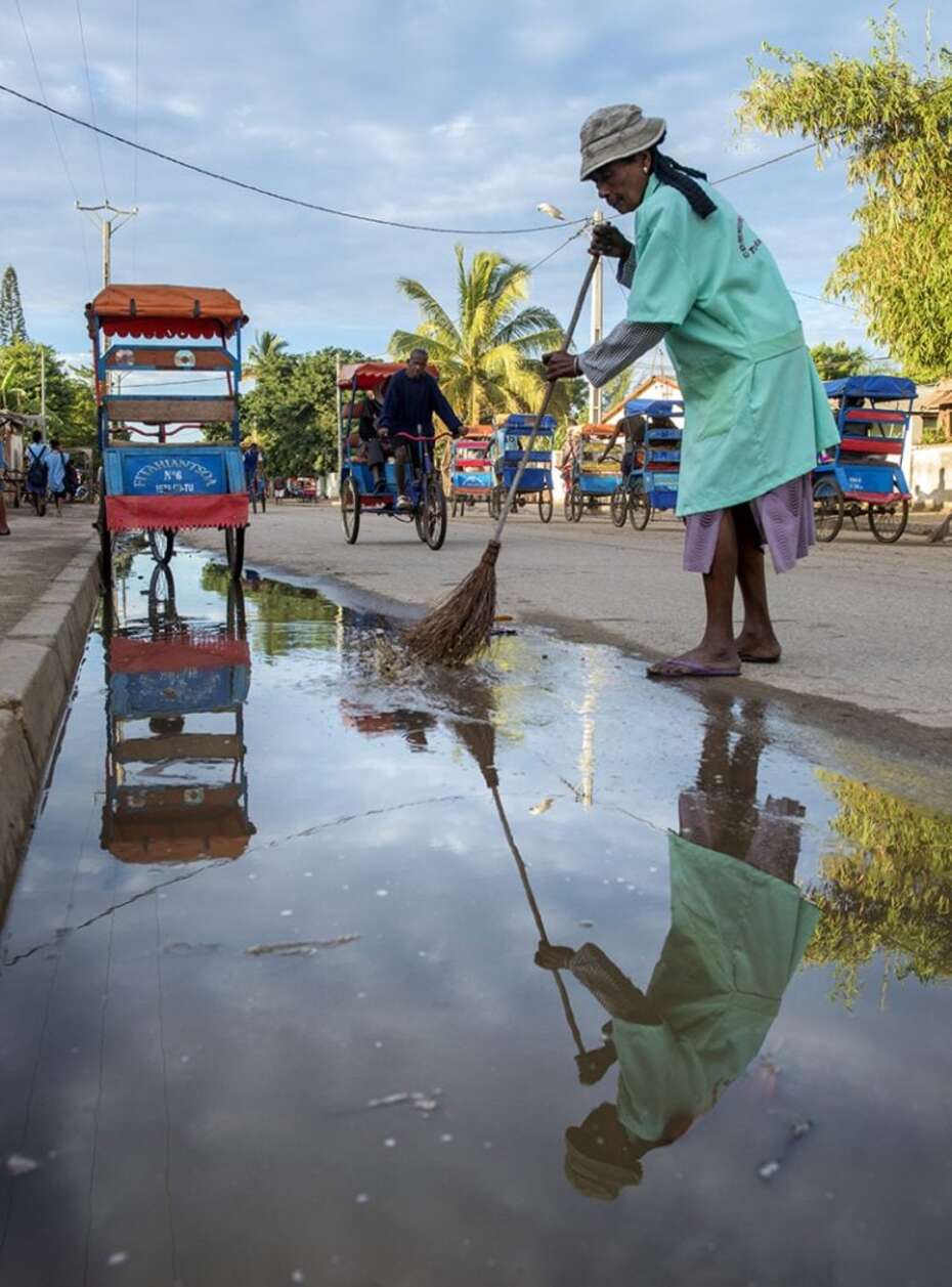 Straßenfeger reinigt die Straße 