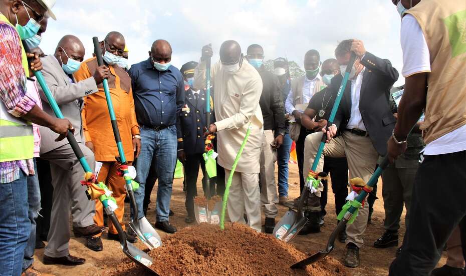 Mehrere Männer stechen mit Spaten in einen Erdhaufen.