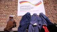 2022-lebensmittel-verteilung-frauen-afghanistan_C_Sabawoon.jpg Drei Frauen mit blauen Burkas und ein Junge warten bei einer Lebensmittelverteilung in Kabul, Afghanistan.