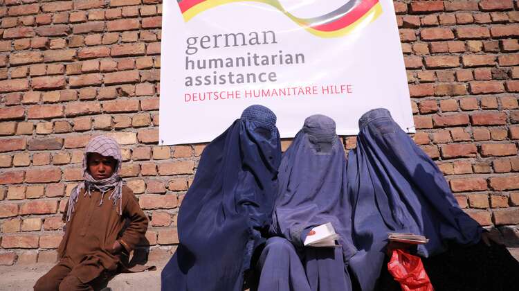 2022-lebensmittel-verteilung-frauen-afghanistan_C_Sabawoon.jpg Drei Frauen mit blauen Burkas und ein Junge warten bei einer Lebensmittelverteilung in Kabul, Afghanistan.