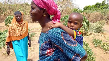 Eine Frau mit ihrem Baby auf dem Rücken.