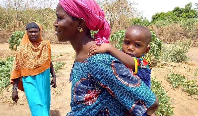 Eine Frau mit ihrem Baby auf dem Rücken.