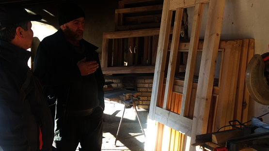 Zwei Männer stehen in einer Glaswerkstatt.