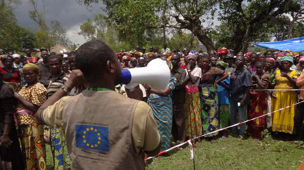 Ein Mann spricht durch ein Megaphon zu einer Menschenmenge in Katoto, Kongo