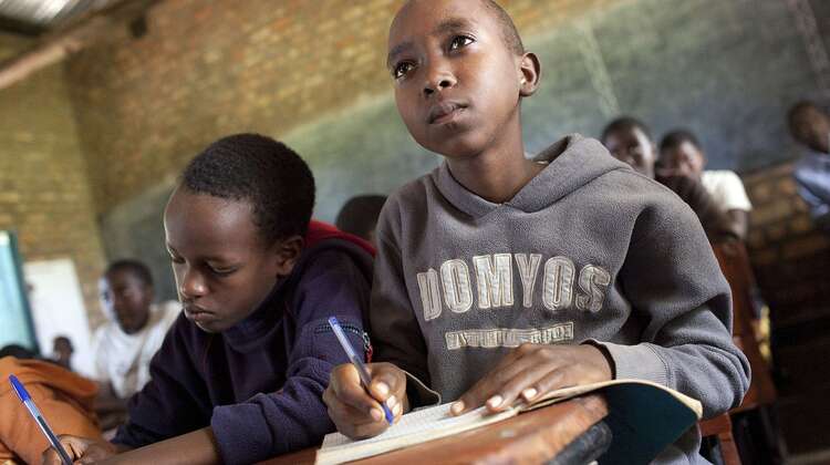 Zwei Schüler machen im Unterricht Notizen.