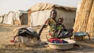 Eine Frau mit ihrem Kind beim Wäsche waschen im Flüchtlingscamp Bentiu, Südsudan.