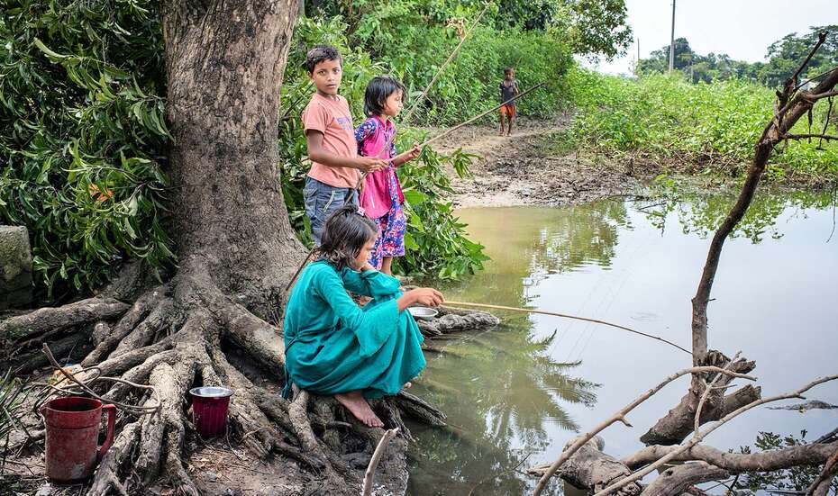 Kinder versammeln sich am Rande von unter Wasser stehendem Land