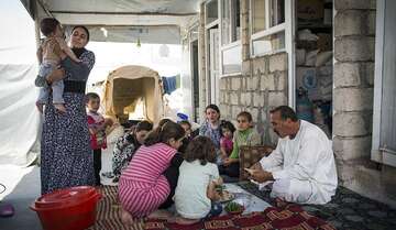 Eine Familie der vom IS verfolgten Minderheit der Jesiden hat Unterschlupf in einem Rohbau nur wenige Kilometer von der Front entfernt gefunden. Bild: © Lass/Welthungerhilfe Eine Familie Jesiden sitzt zusammen im Kreis