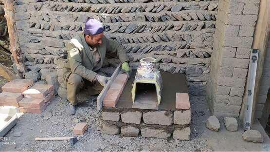 Ein Mann mauert einen Ofen.