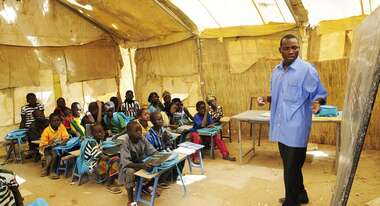 Ein Lehrer erklärt seiner Klasse etwas an der Tafel