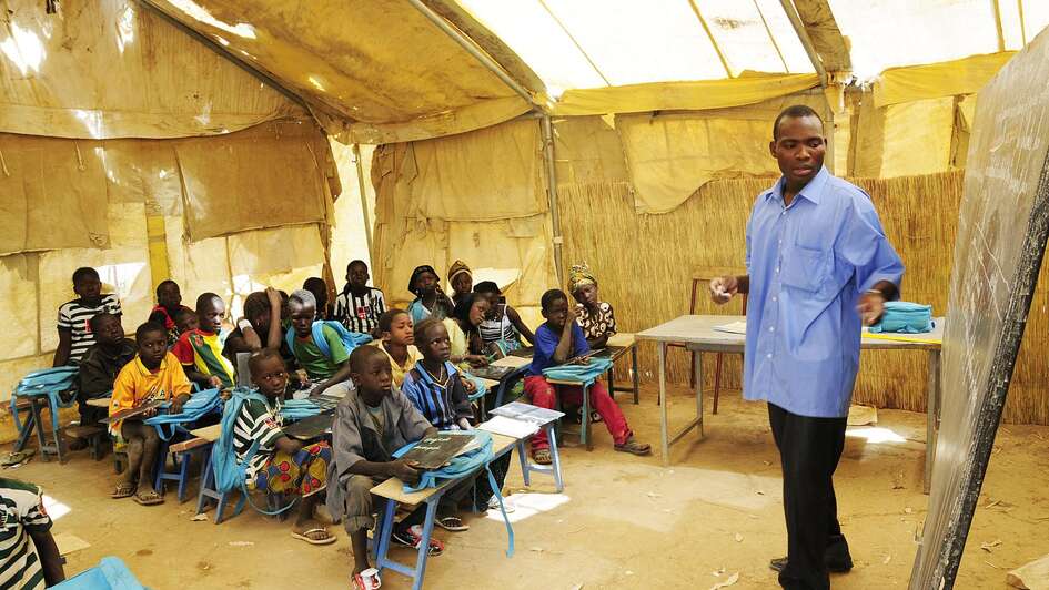 Ein Lehrer erklärt seiner Klasse etwas an der Tafel