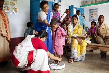 Kind wird bei einer medizinische Untersuchung in der Schule gewogen