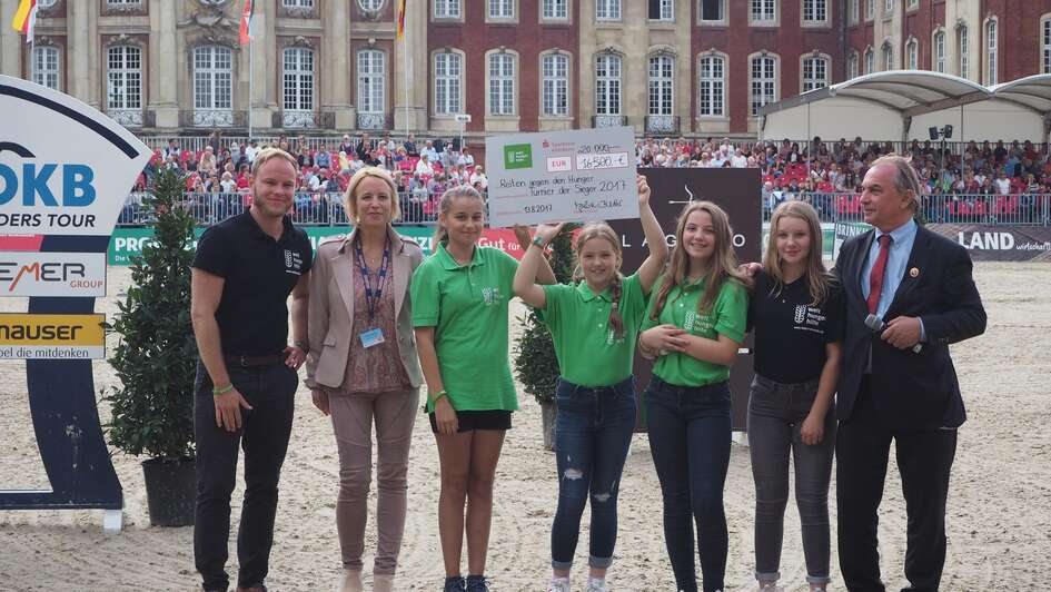 Scheckübergabe vor dem Schloss: Ein großes Dankeschön an Julia Becker, Beirätin von Reiten gegen den Hunger, und Hendrik Snoek, Organisator des Turnieres und großzügiger Spender, sowie an die zahlreichen weiteren Unterstützerinnen und Unterstützer. 