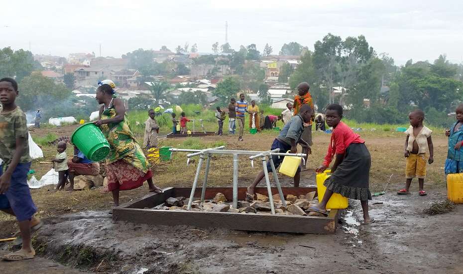 Menschen schöpfen Wasser an einer Notwasserstelle