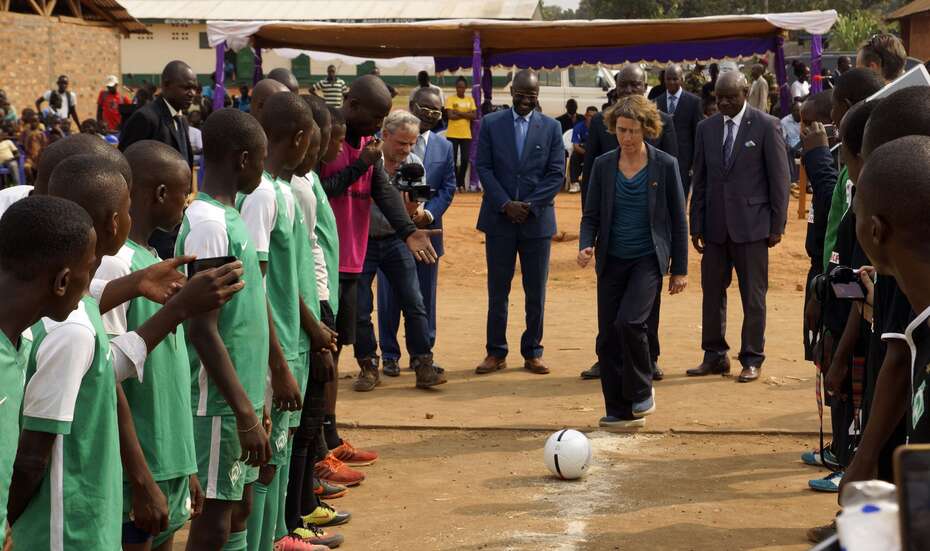Annika Wandscher in der Mitte, um sie herum viele Kinder. Sie ist dabei, den Ball anzustoßen.