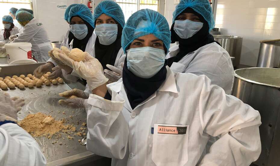 Für Menschen im Libanon spenden. Bild: Frauen in stehen in einer Küche, sie tragen Schutzkleidung.