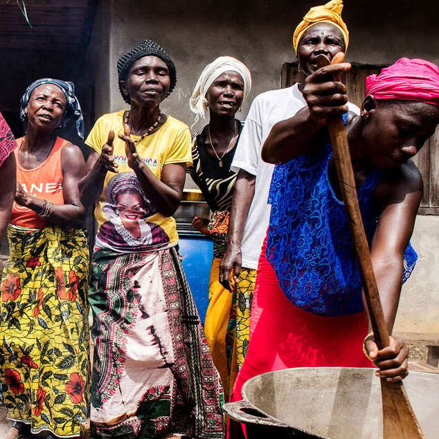 Frauen kochen und singen.