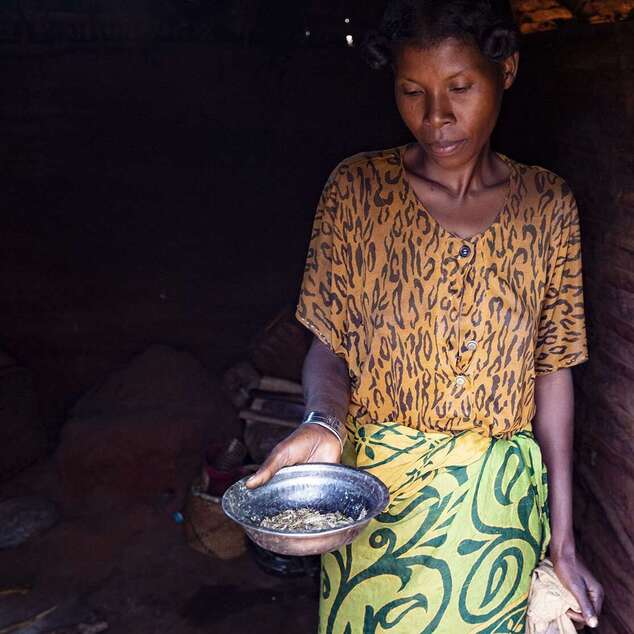 Eine Frau zeigt eine fast leere Metallschüssel, Madagaskar 2021.