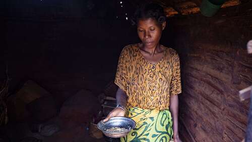 Eine Frau zeigt eine fast leere Metallschüssel, Madagaskar 2021.