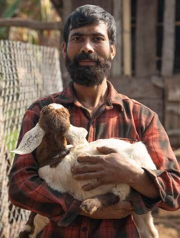 Portraitbild von Ziegenhirte mit Zicklein auf dem Arm