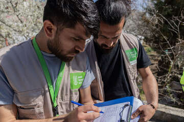 Zwei Männer prüfen eine Liste auf einem Klemmbrett