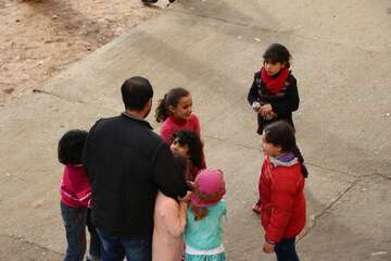 Lehrer steht mit seinen Schülerinnen draußen