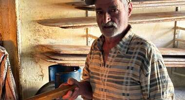 Ein älterer Mann steht in einem Raum, im Hintergrund sieht man leere Regale.