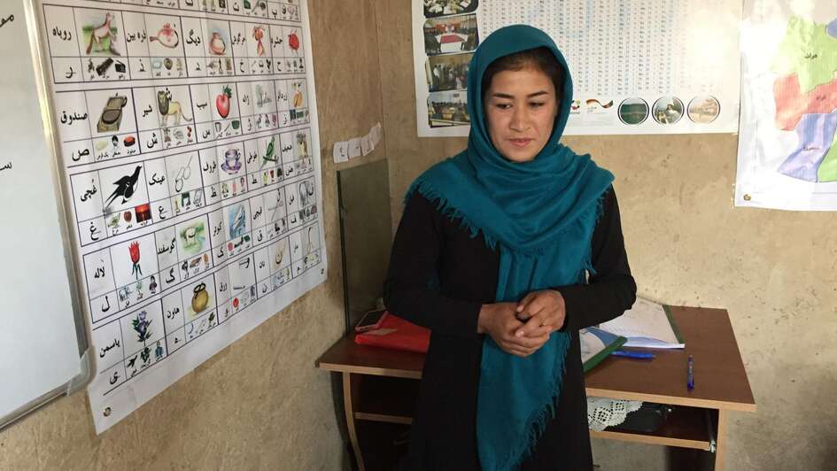 Eine Frau steht vor einem Lernposter