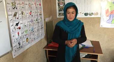 Eine Frau steht vor einem Lernposter