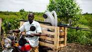 Ein Bauer in Uganda auf einem Moped, 2021.