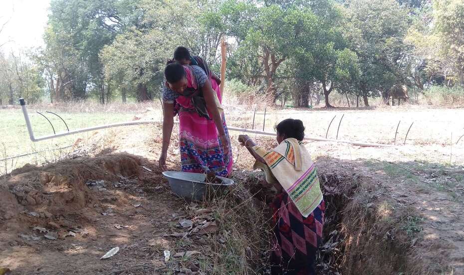 Zwei Frauen im ländlichen Indien legen einen Wassergraben an