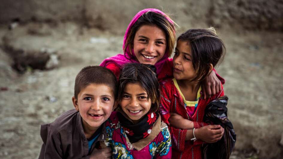 Eine Gruppe Kinder in bunter Kleidung nimmt an einem Kinderzirkus teil