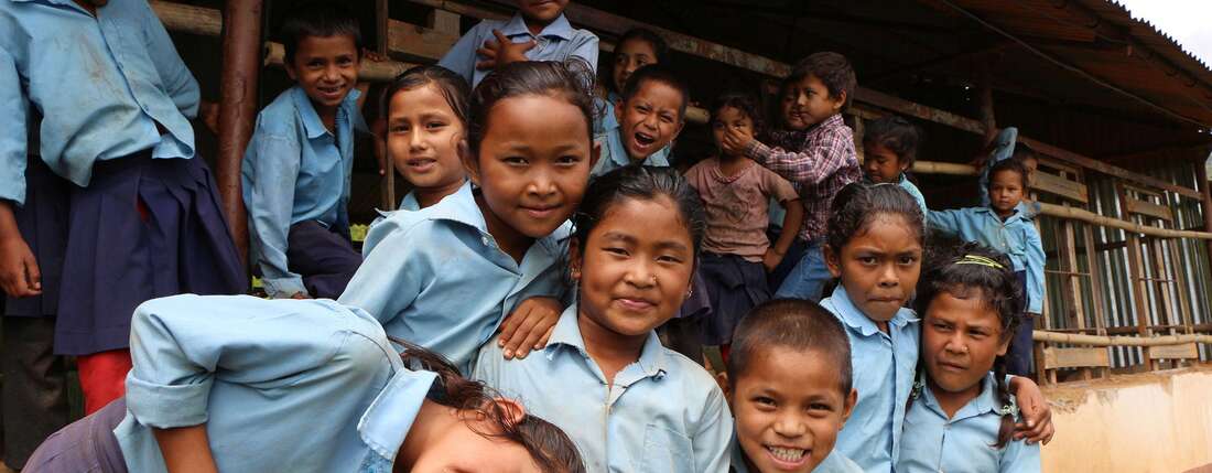 Kinder in Uniform vor einer Schule
