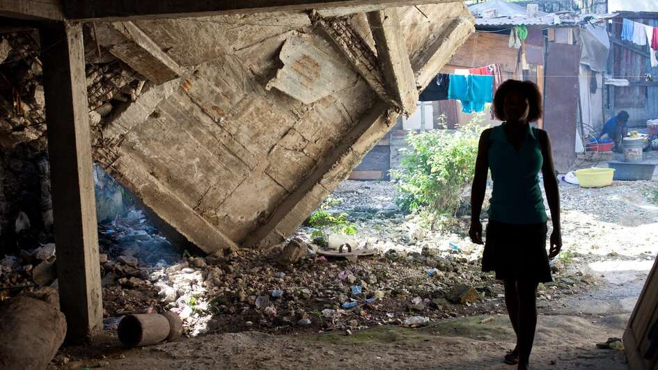 Frau läuft unter Trümmern her