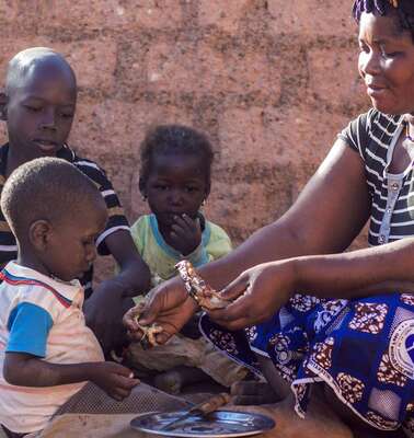Eine Frau füttert ihr Kleinkind.