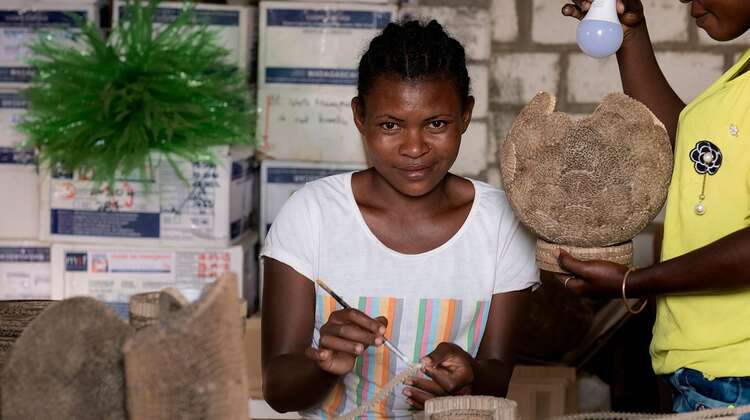 Zwei Frauen basteln mit Altpapier dekorative Gegenstände.