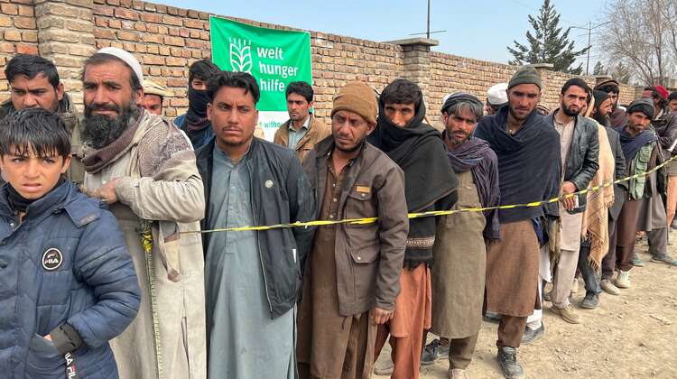 2022-lebensmittel-verteilung-maenner-afghanistan_C_Sabawoon.jpg Männer stehen bei einer Lebensmittelverteilung in Kabul, Afghanistan, Schlange.