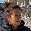 Eine Frau steht vor eingestürzten Gebäuden.