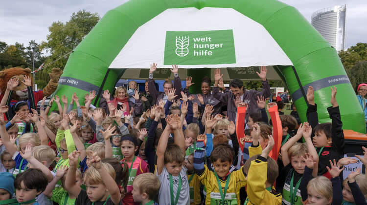 Kinder mit Laufnummer halten ihre Hände nach oben.