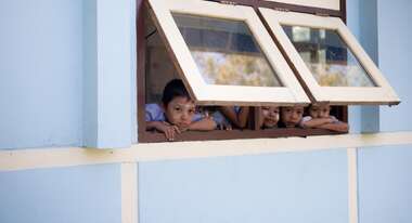 Schulkinder schauen aus dem Fenster.