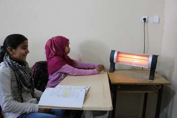 Bei Regen und feuchter Kälte fehlen besonders viele der 650 Schülerinnen und Schüler Zwei Schülerinnen mit einem Heizkörper vor ihrem Tisch