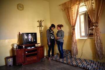 Frauen stehen in einem Wohnraum.