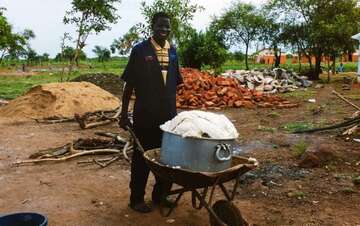 Ein Mitarbeiter des UNHCR liefert Schubkarrenweise Essen für fast 4300 Flüchtlinge.
