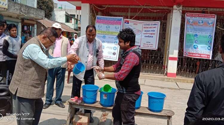 Zwei Männer waschen sich an einer Hygienestation die Hände.