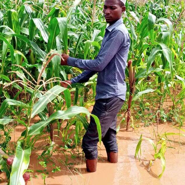 Jetzt spenden: Überschwemmungen in Ostafrika – Ein Mann steht in einem überschwemmten Feld.